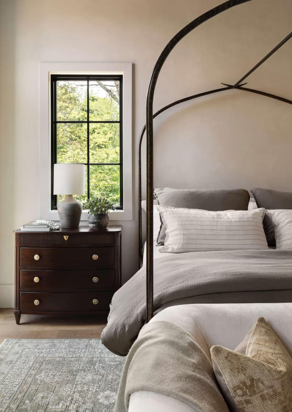That metal canopy bed against the soft colors is doing it for me.