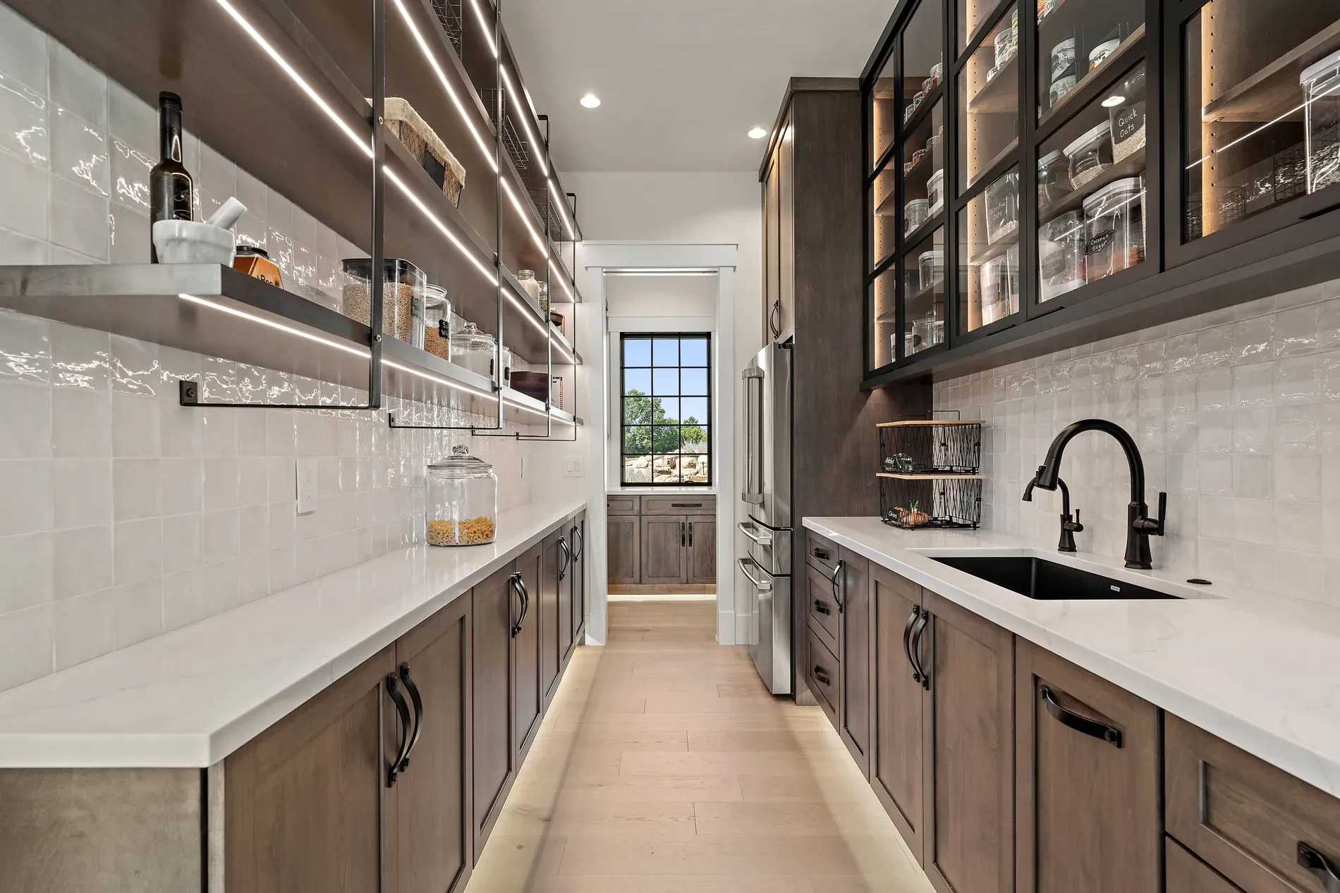 Warm wood cabinets, black hardware, open shelves showing off the pretty plates.