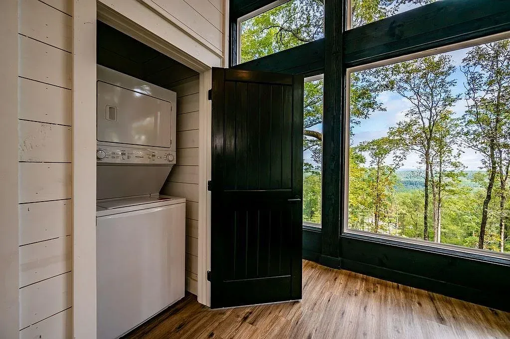 Hidden laundry nook with black door against white shiplap. Simple and tidy.