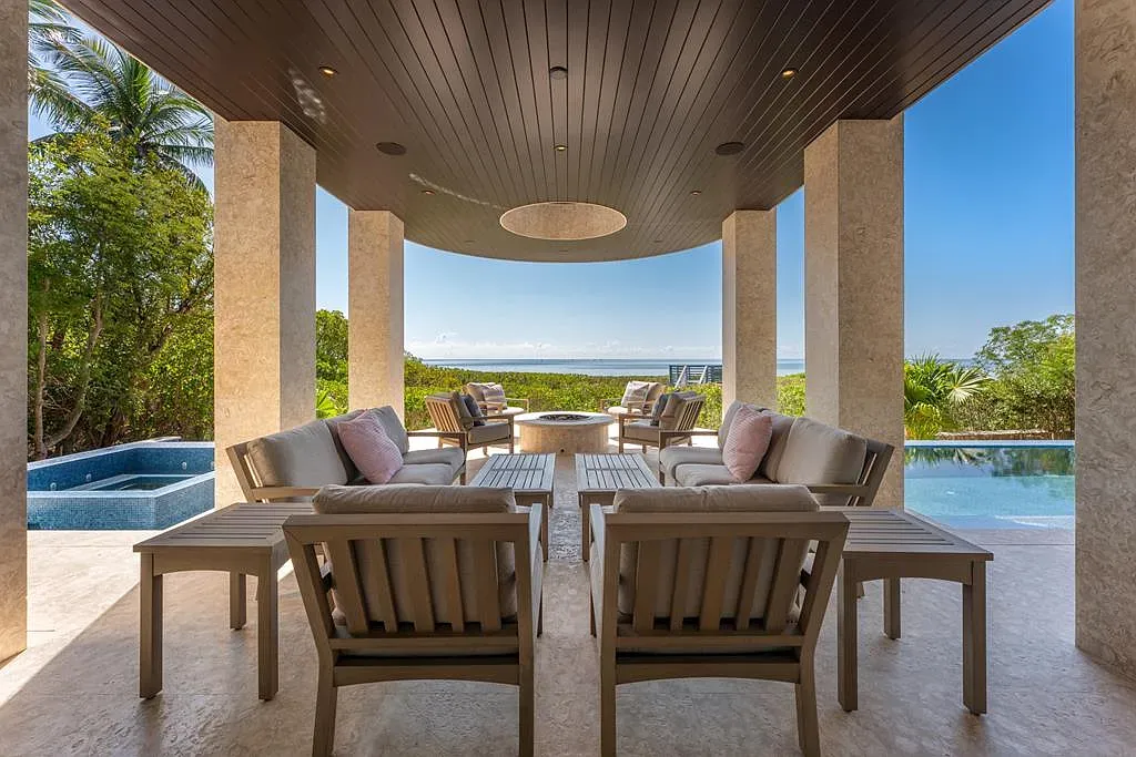 Outdoor lounge meant for the view. Pale stone underfoot, everything pointed at the ocean.