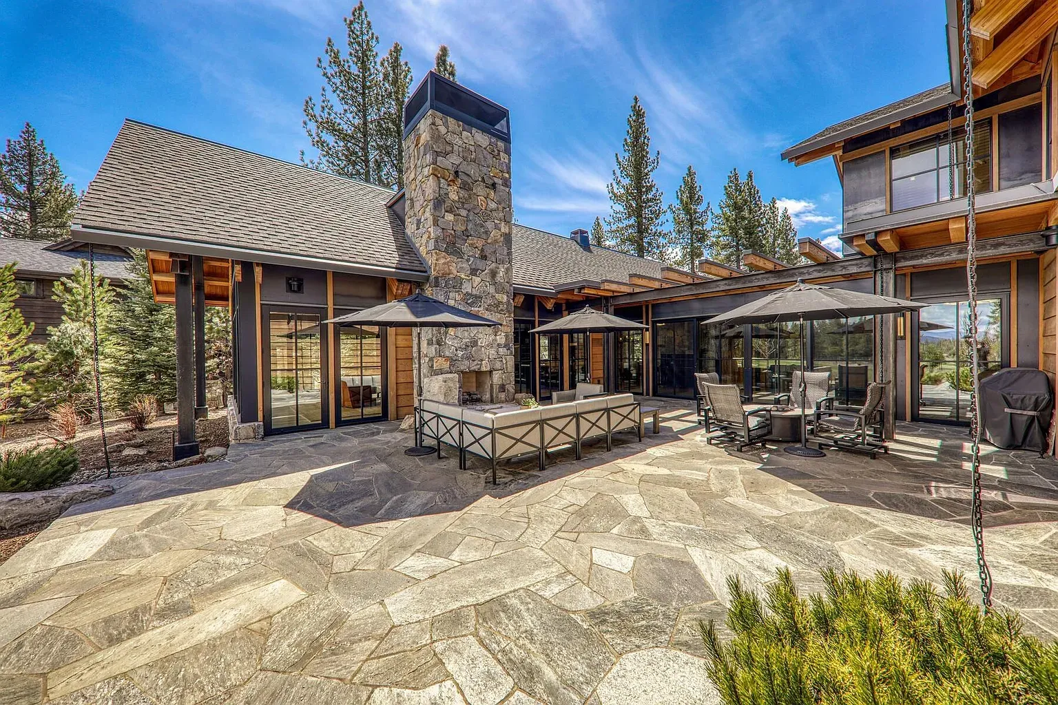 Outdoor lounge 2.0—big stone hearth, clean lines, plenty of seats for chilly nights.