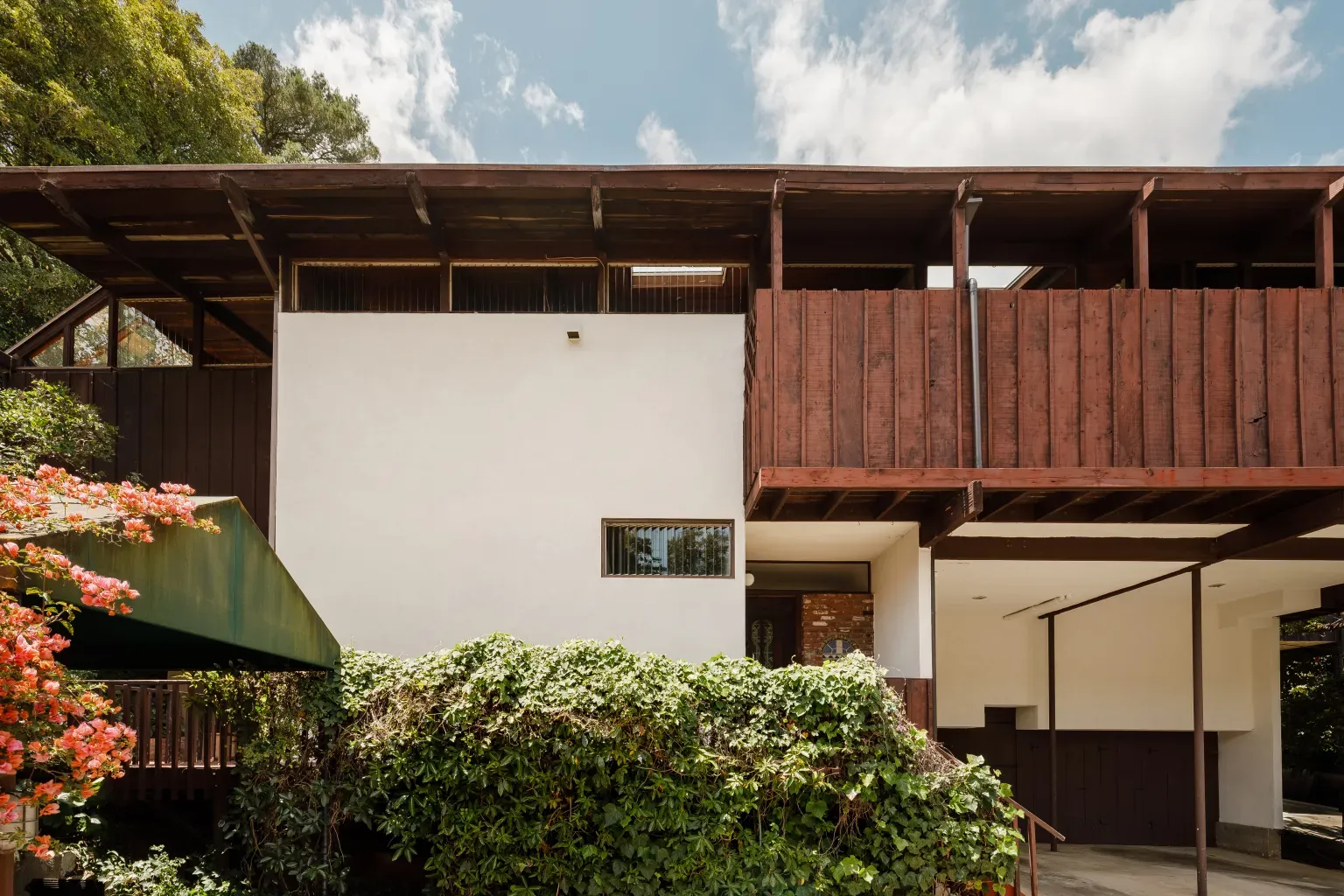 Exterior mix of white stucco and wood. Clean lines, looks thoughtfully put together.