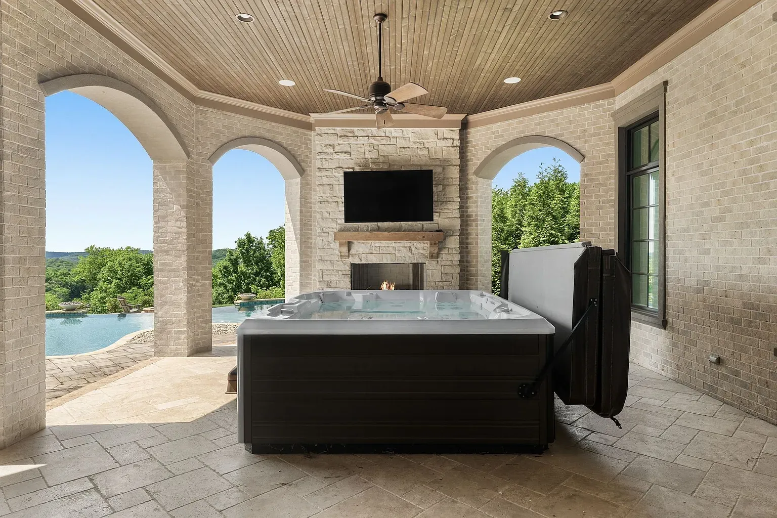 Indoor hot tub framed by arches and stone. Spa day without leaving.