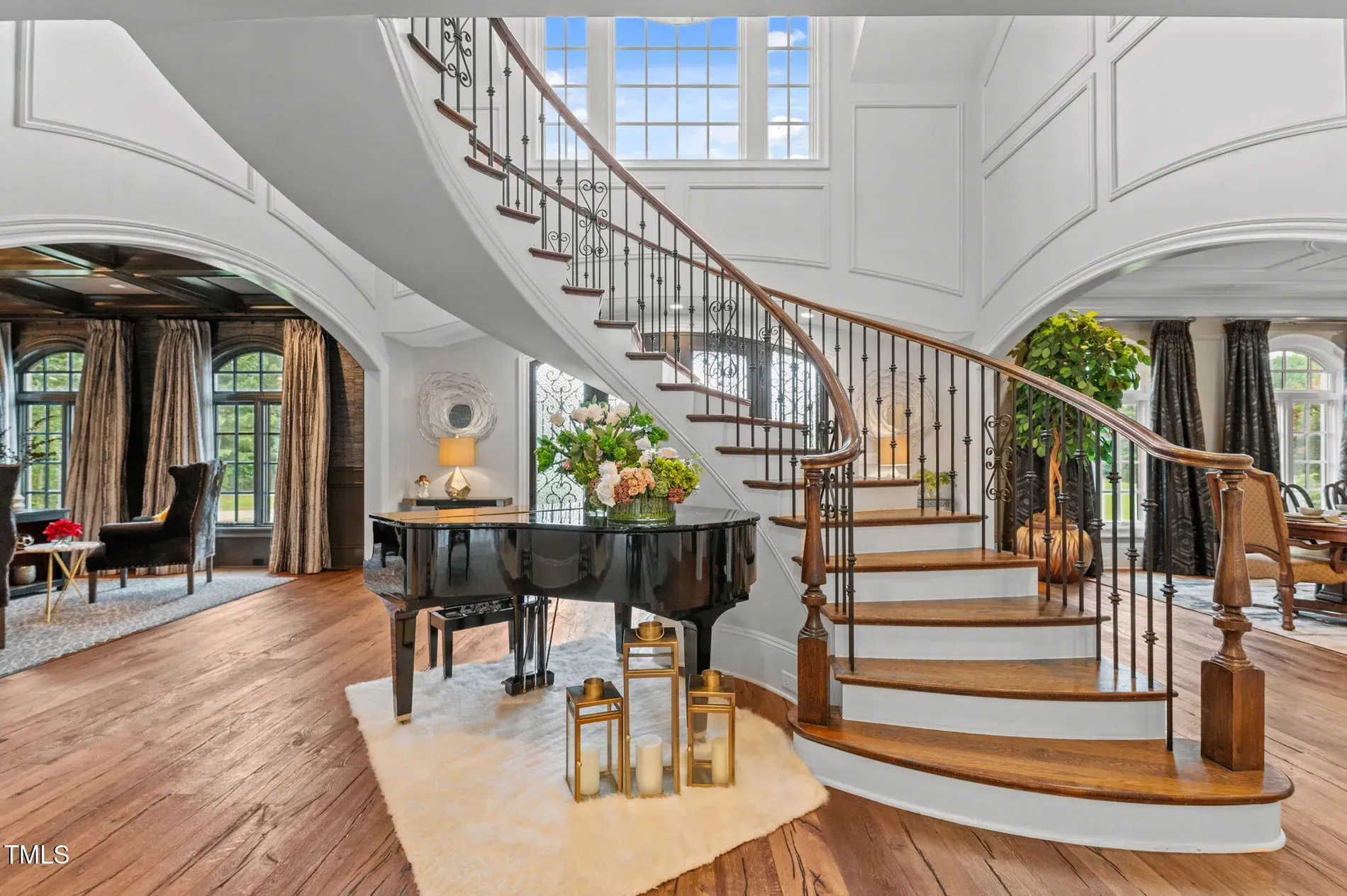 Inside, this foyer spirals hard. Wood treads, iron railings—dramatic but tasteful.
