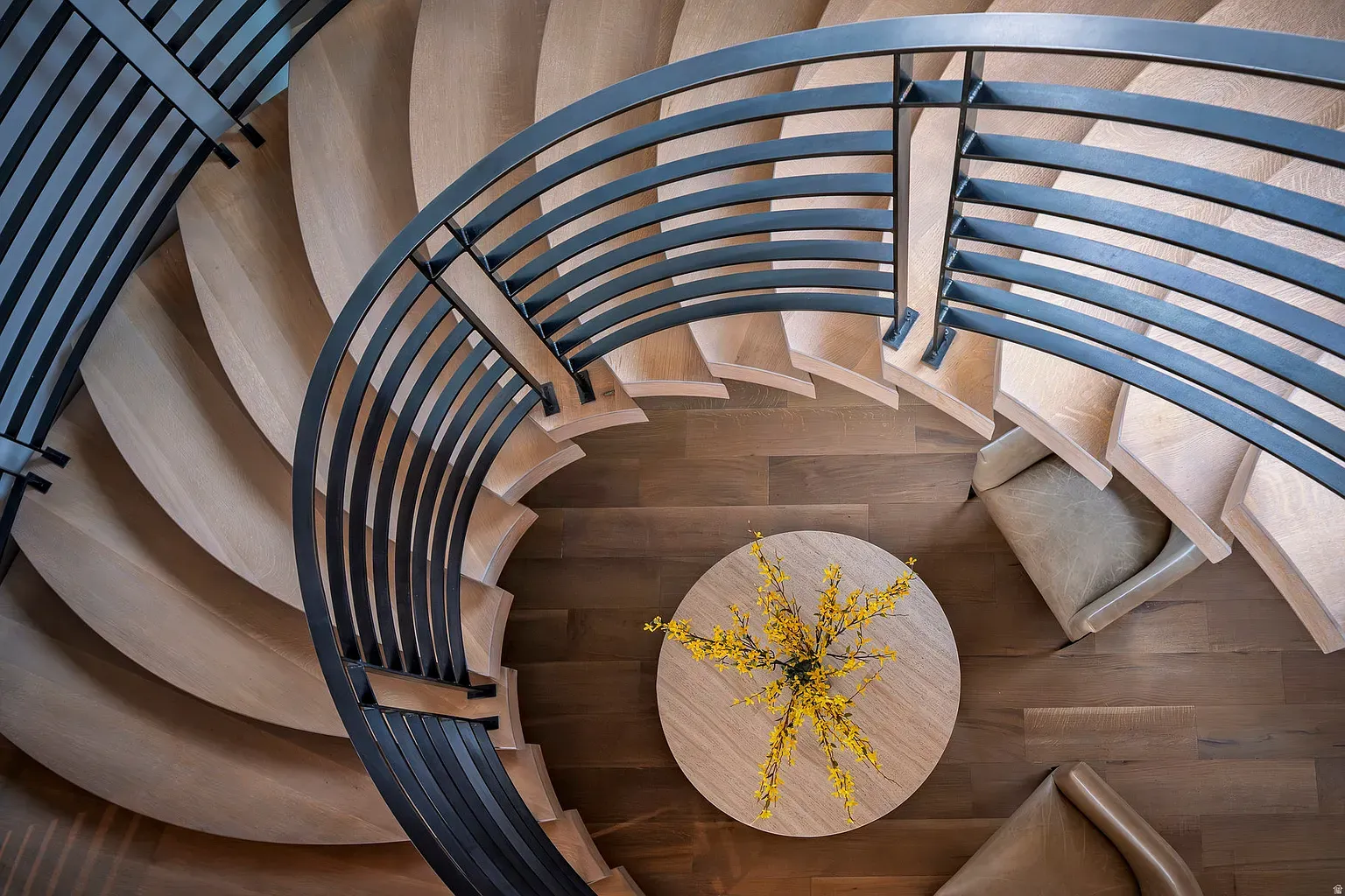 The spiral staircase looks a ribbon. Warm wood, super clean lines.