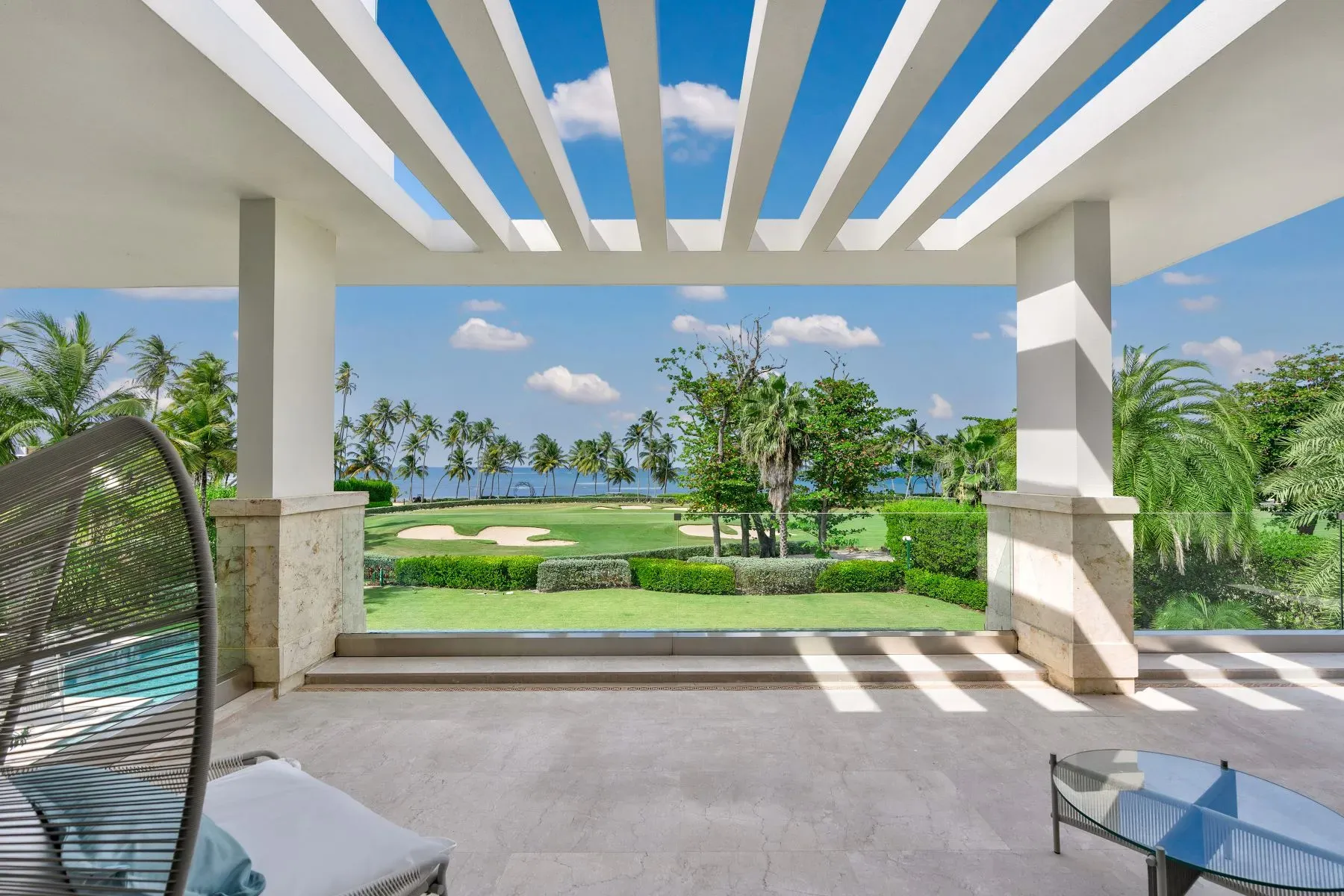 Covered lounge with white columns and stone floors. Breezy and bright.