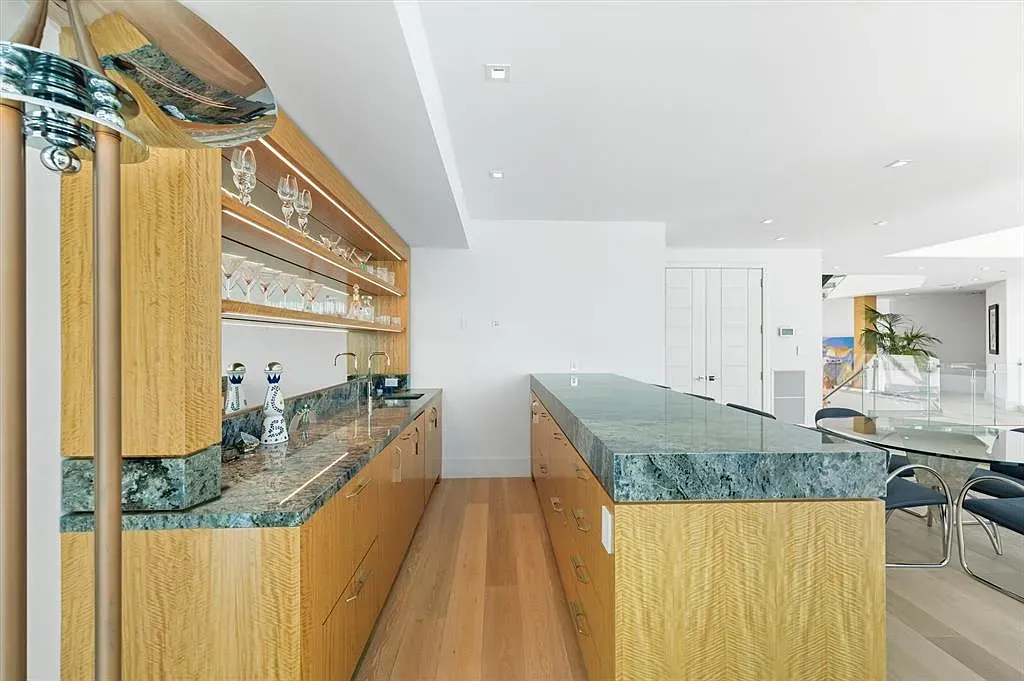 That emerald island is the whole personality. Warm wood keeps it grounded.