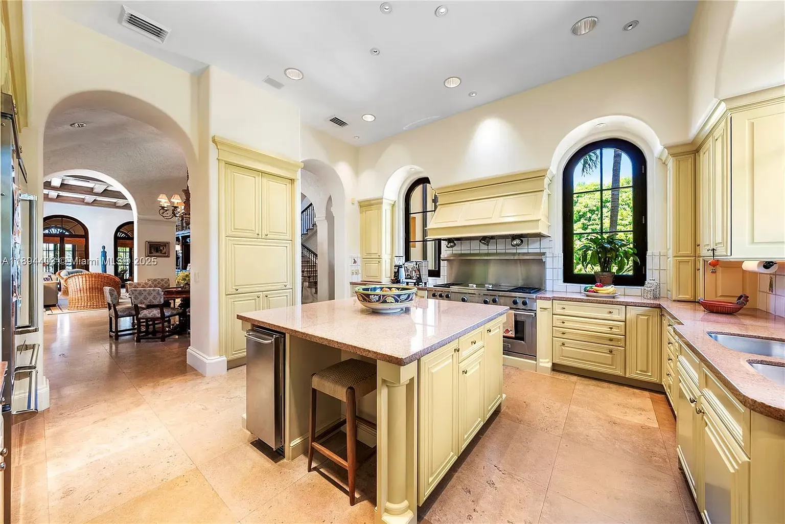 Butter-yellow kitchen, light stone counters, big island energy. Cheerful without screaming.