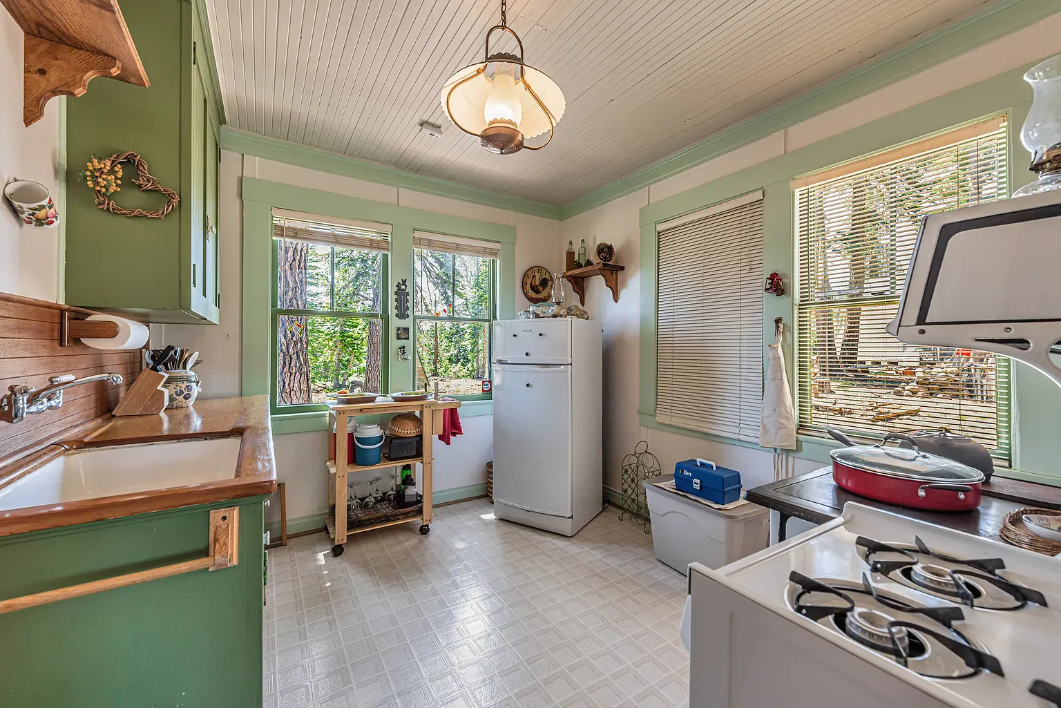 Soft green kitchen with beadboard ceiling and old floors—cute and cozy.