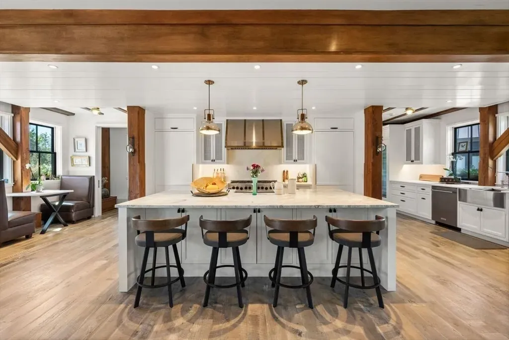 Clean marble island, chunky veining. Four stools daring me to snack here.