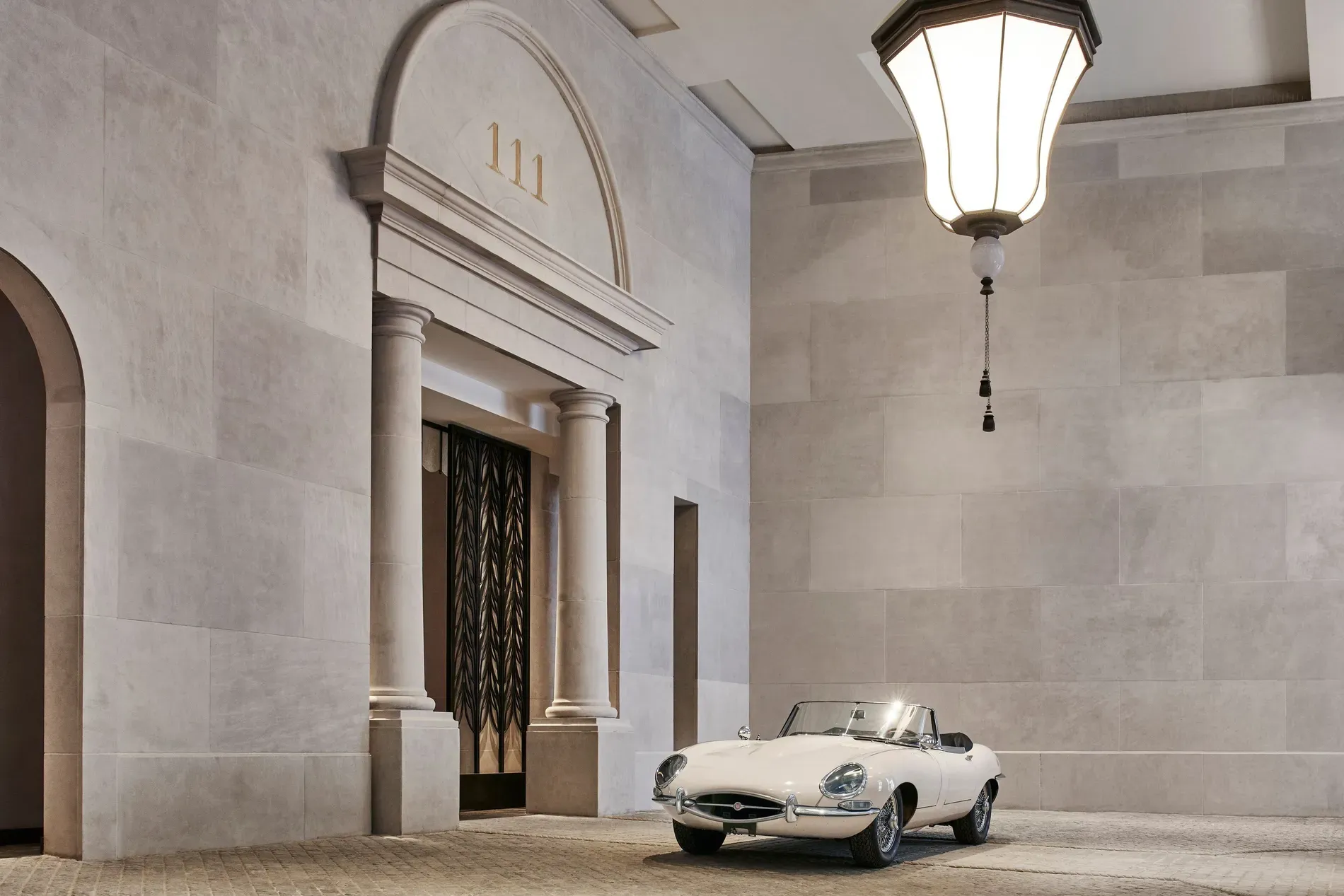 Okay, this entry — high ceiling, huge pendant, beige everything.