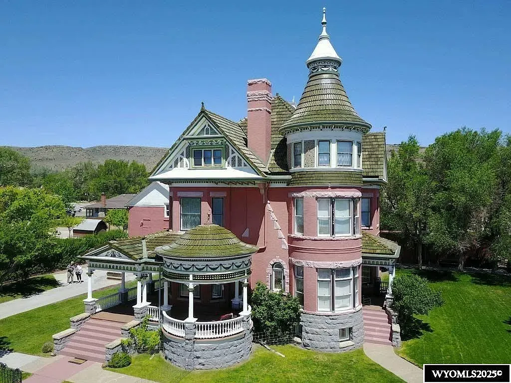 Pink Victorian with a turret? Wraparound porch is begging for iced tea weather.