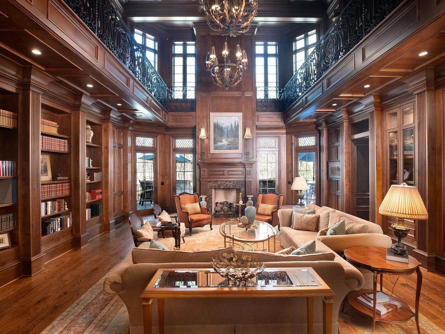 A grand two-story library with wood-paneled walls and bookshelves