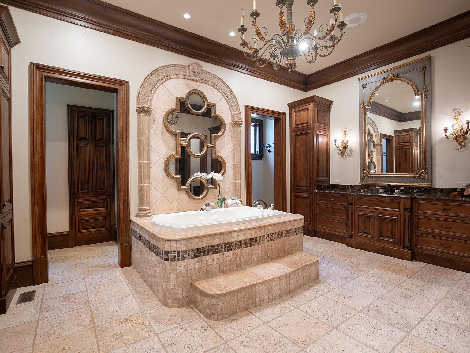 A large primary bathroom with a built-in tub and dark wood vanities