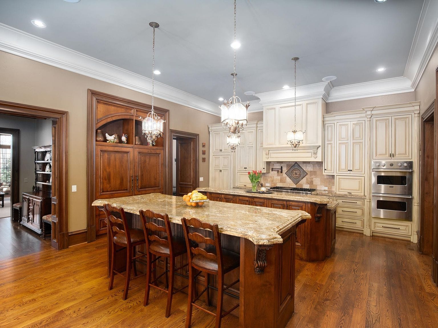 A large kitchen with double islands, wood cabinets, and stone countertops