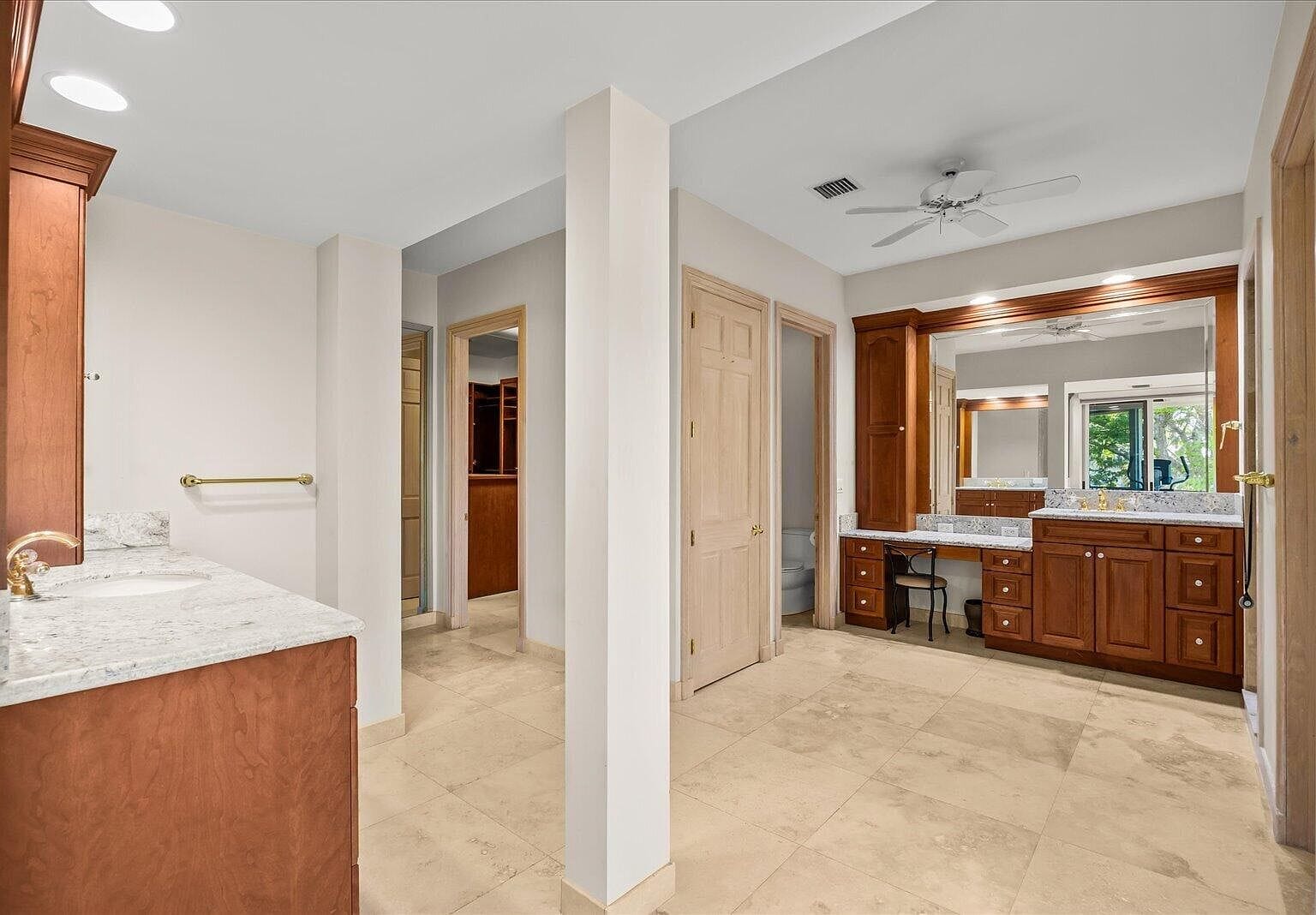 Primary bathroom with dual vanities and marble tile floors