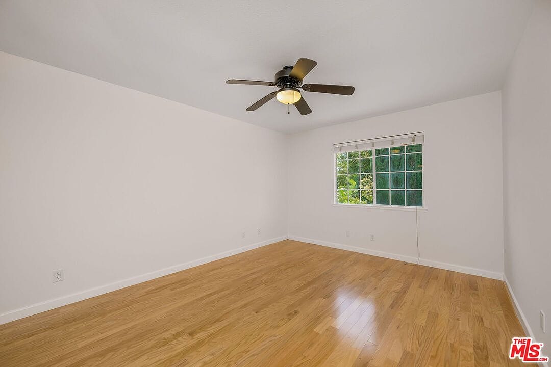 Empty upstairs bedroom with wood flooring