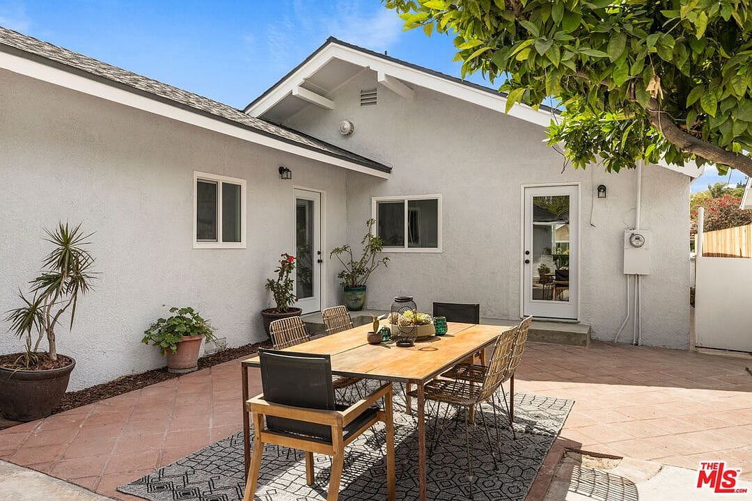 Outdoor dining patio with a wooden table and metal chairs