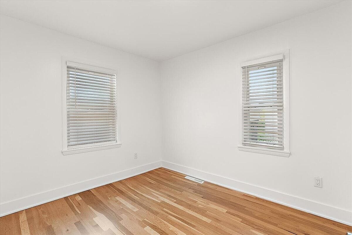 Empty second bedroom with two corner windows