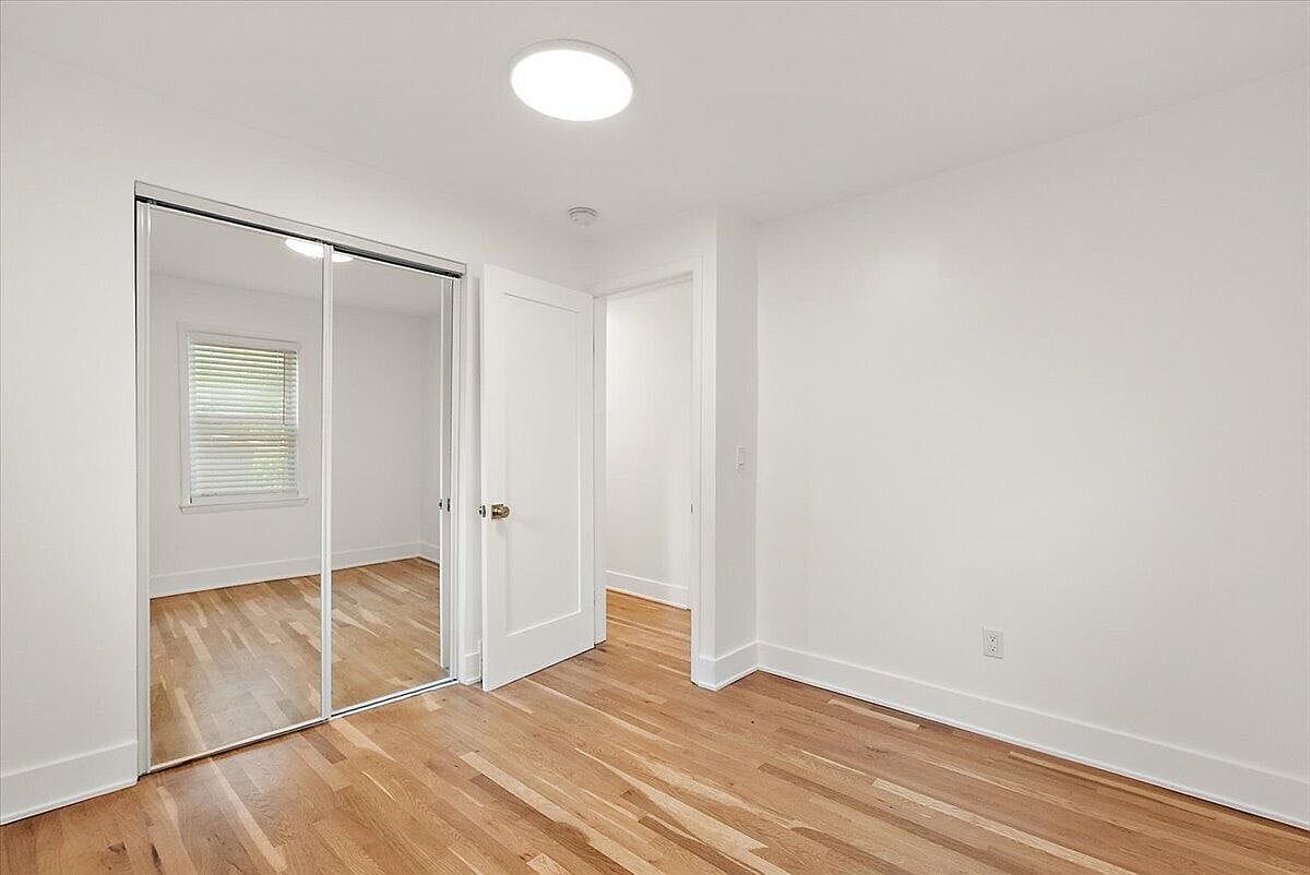 Empty second bedroom showing the sliding mirror closet
