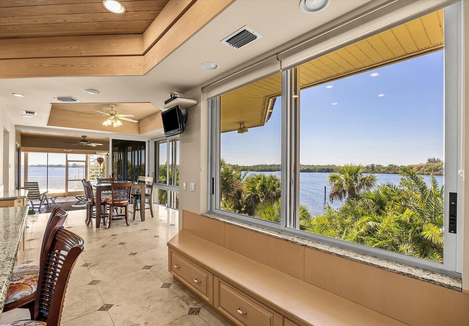 Low wooden bench under a window overlooking the water