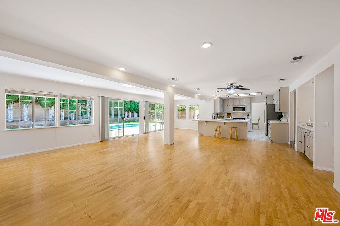 Empty family room showing the expansive wood flooring