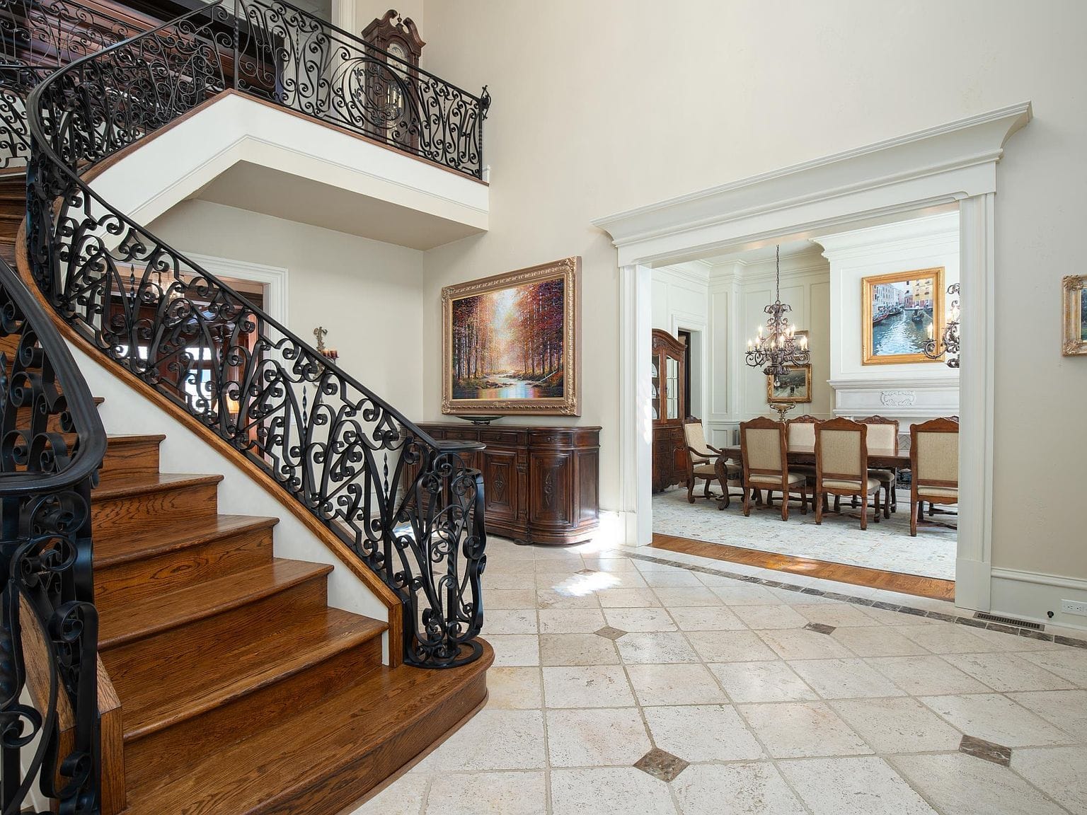 The grand foyer featuring a sweeping wooden staircase and tile floors
