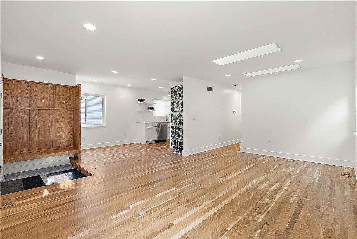 Empty open living area showing the polished hardwood flooring