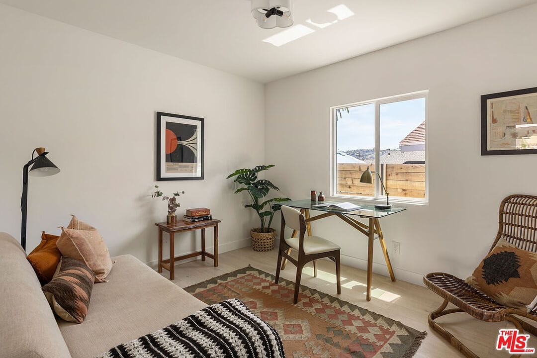 Bedroom styled as a home office with a glass desk and a daybed