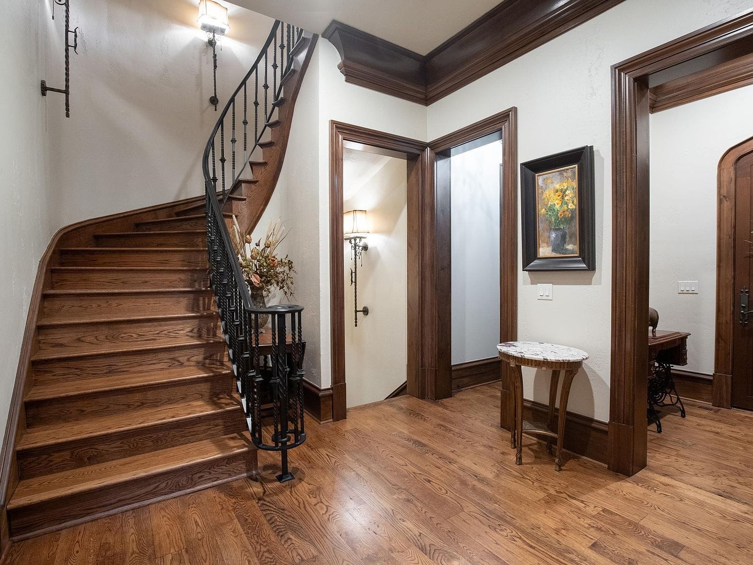 A curved wooden staircase with dark wood trim along the ceiling