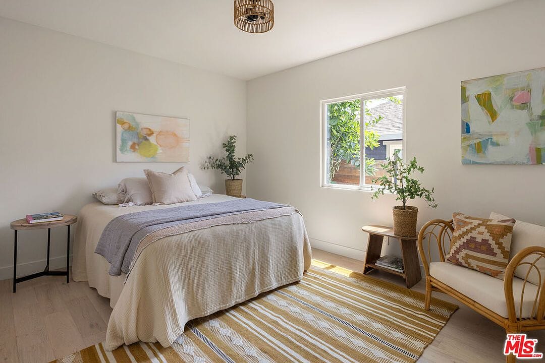 Cozy bedroom with light beige bedding and a patterned rug