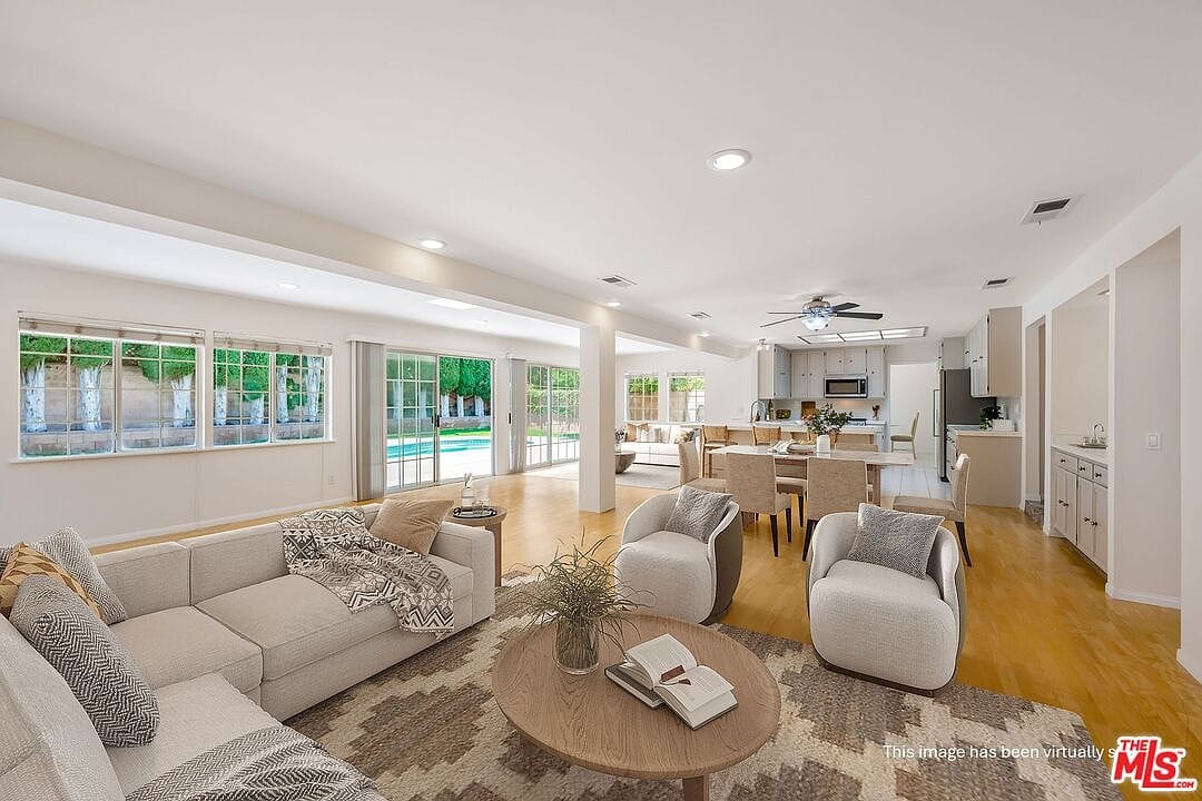Large family room with wood floors and pool views
