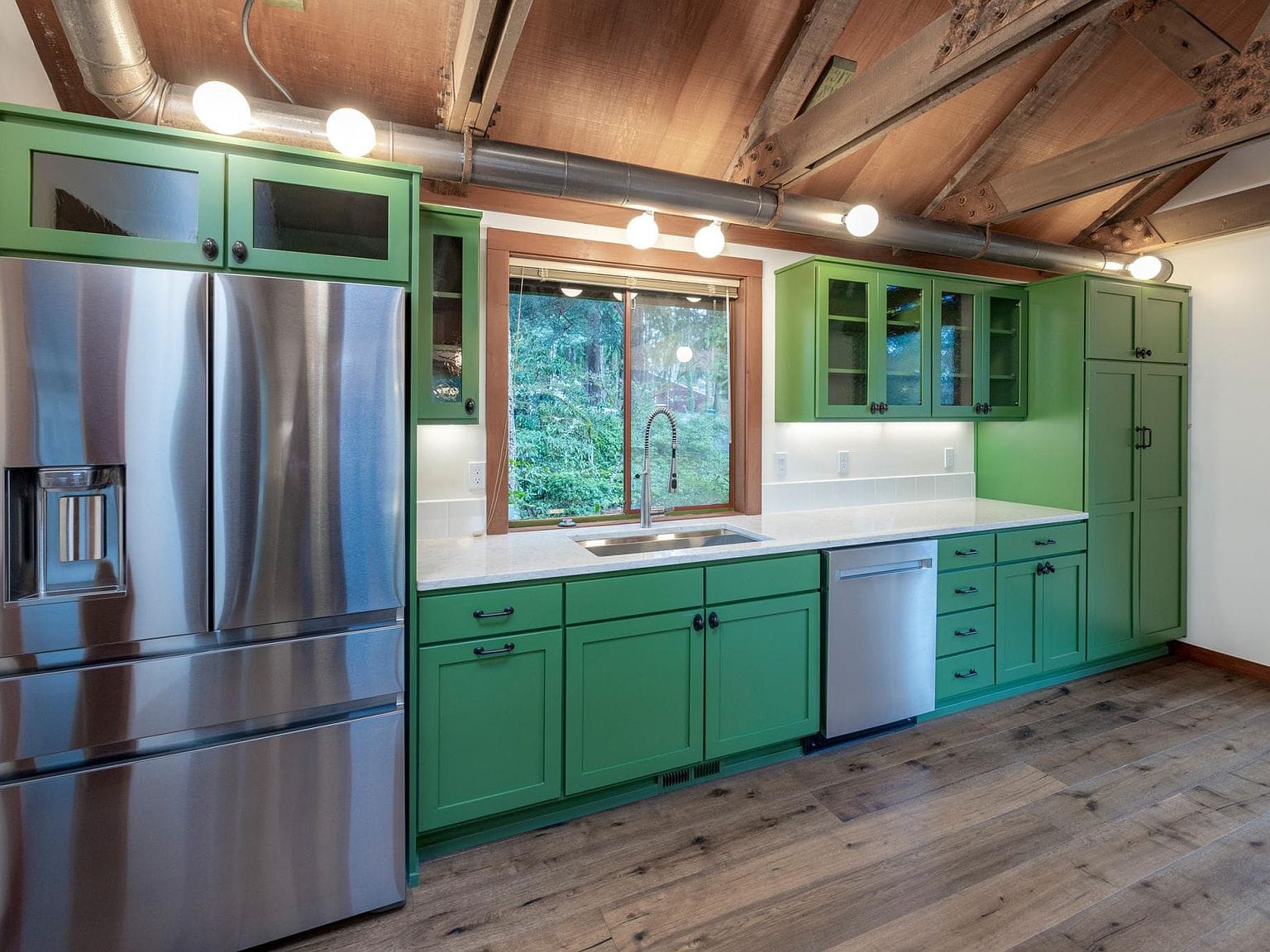 Kitchen sink, green cabinets, stainless fridge
