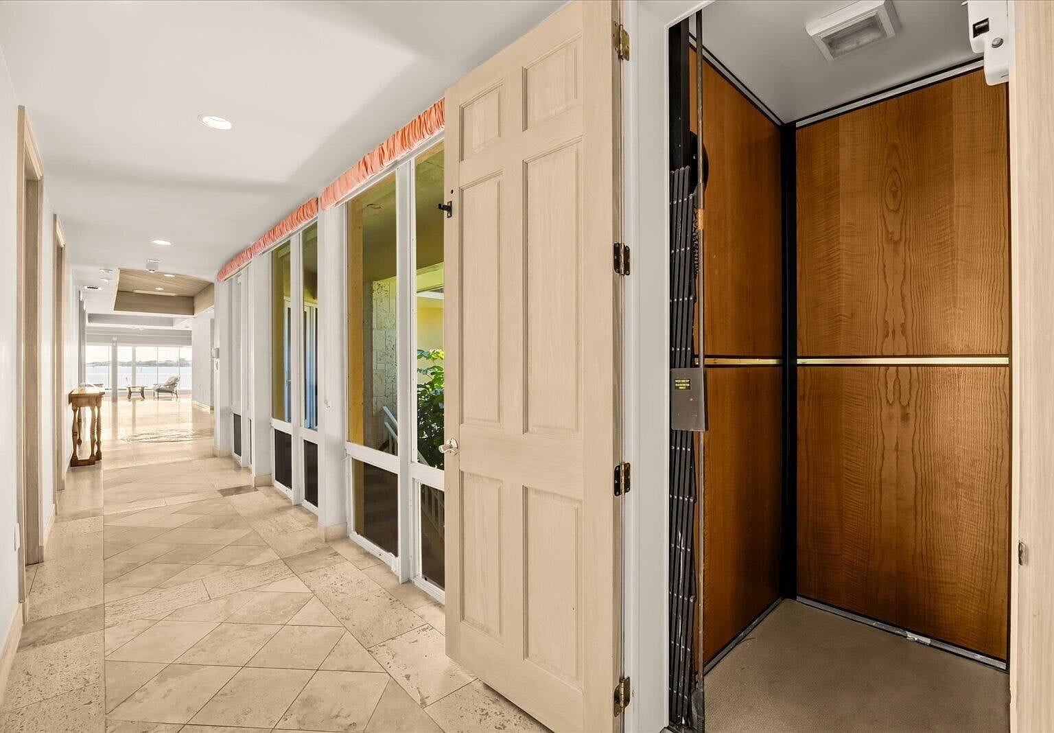 Open elevator door showing wood-paneled interior