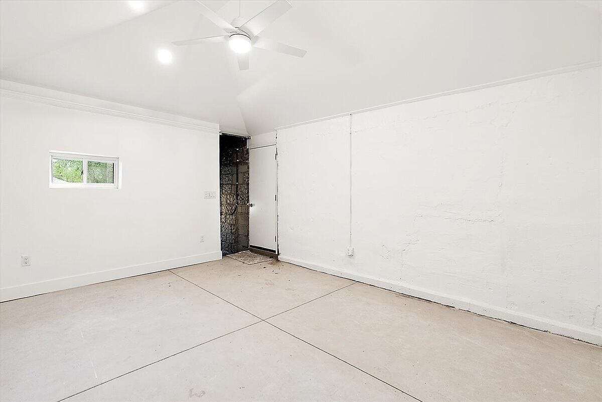 Empty finished room showing the white walls and back exit door