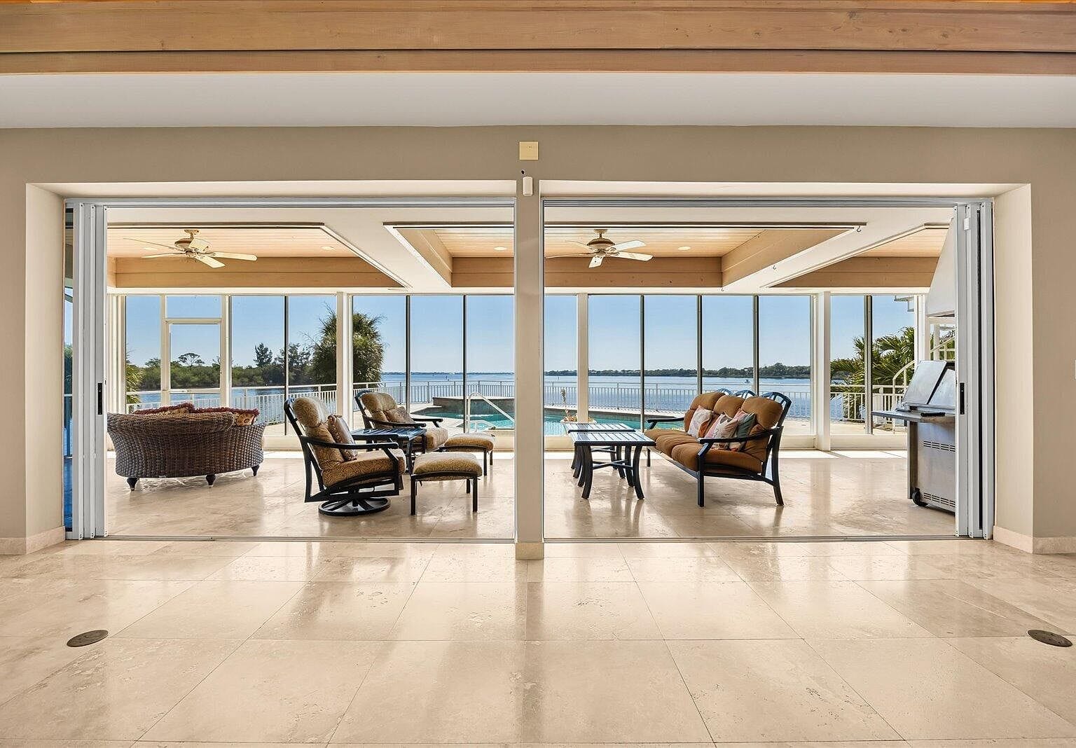 Glass walls opened up completely to the screened patio area