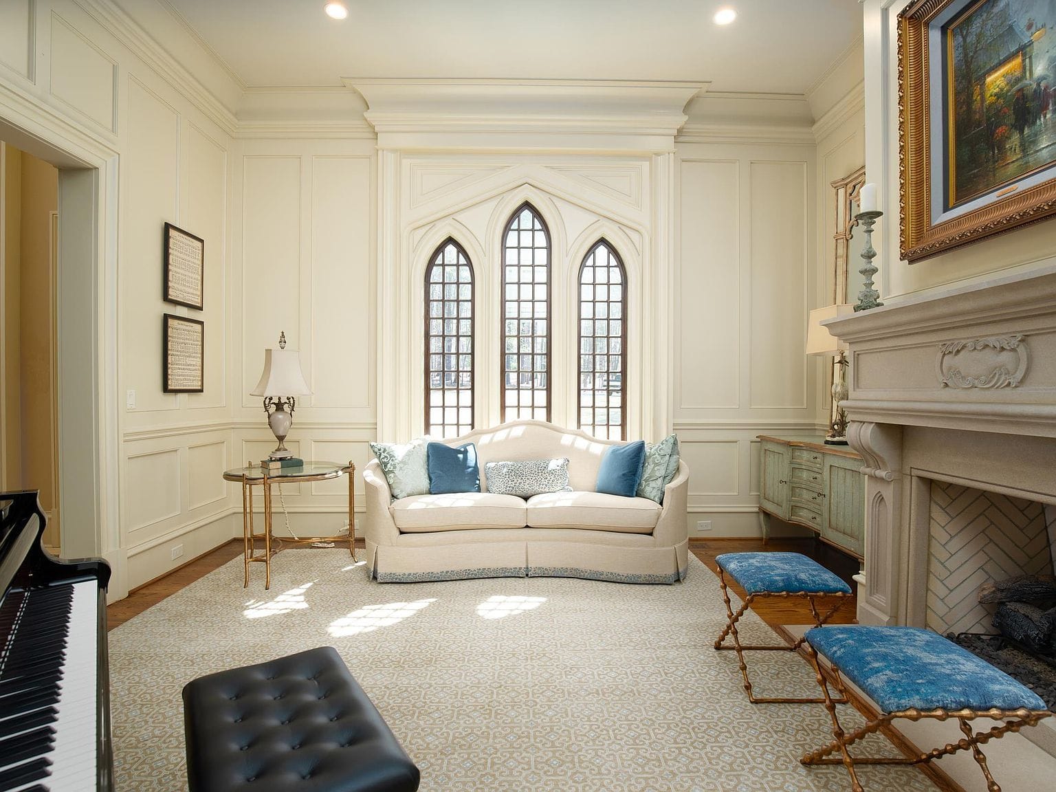 A formal sitting room with a piano, a white sofa, and tall arched windows