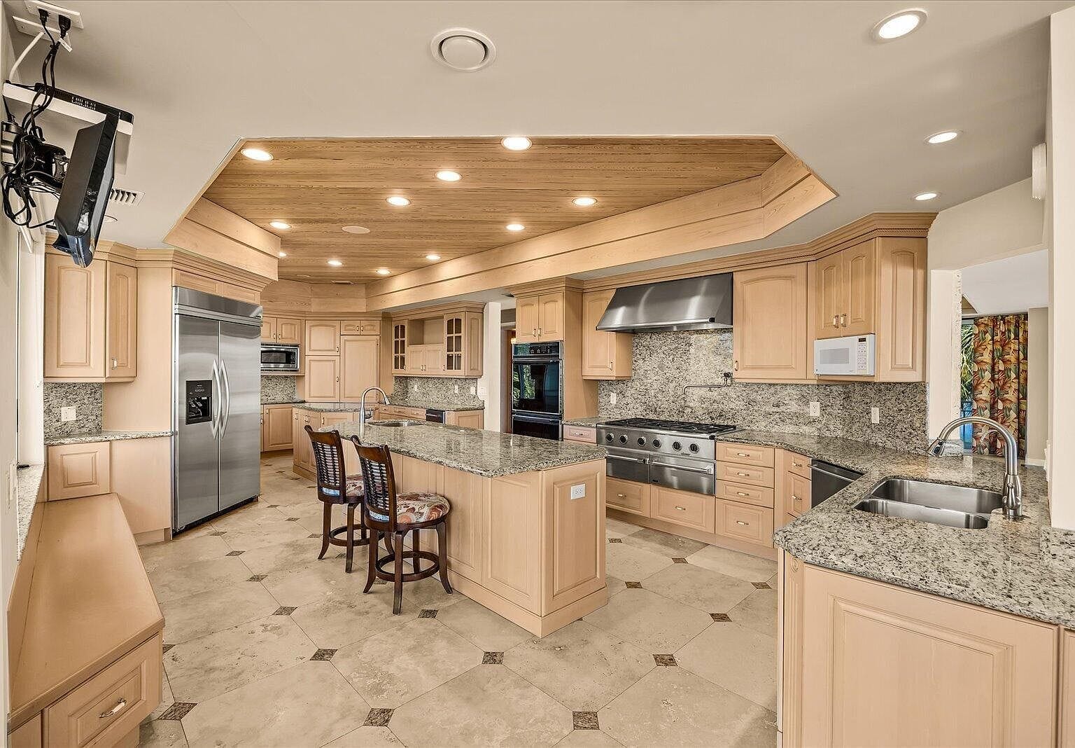 Huge kitchen with double islands and light wood cabinetry