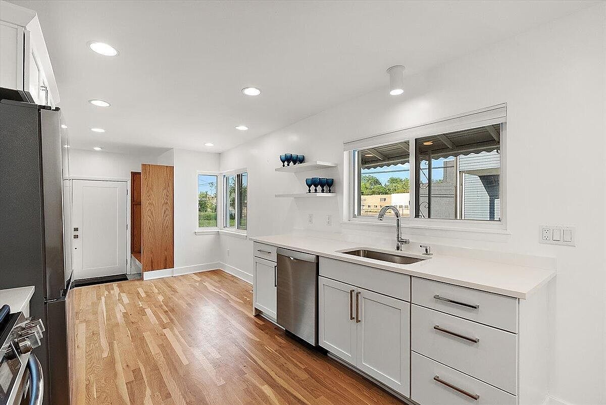 Empty kitchen sink counter under a large sliding window
