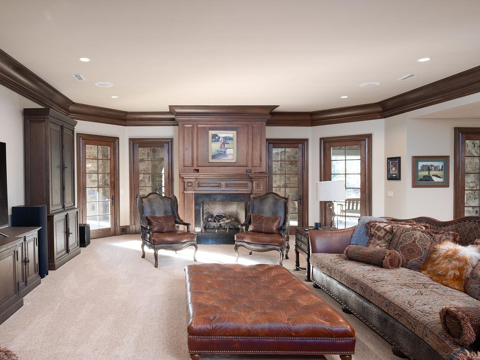 A basement living room with a brick fireplace and leather chairs