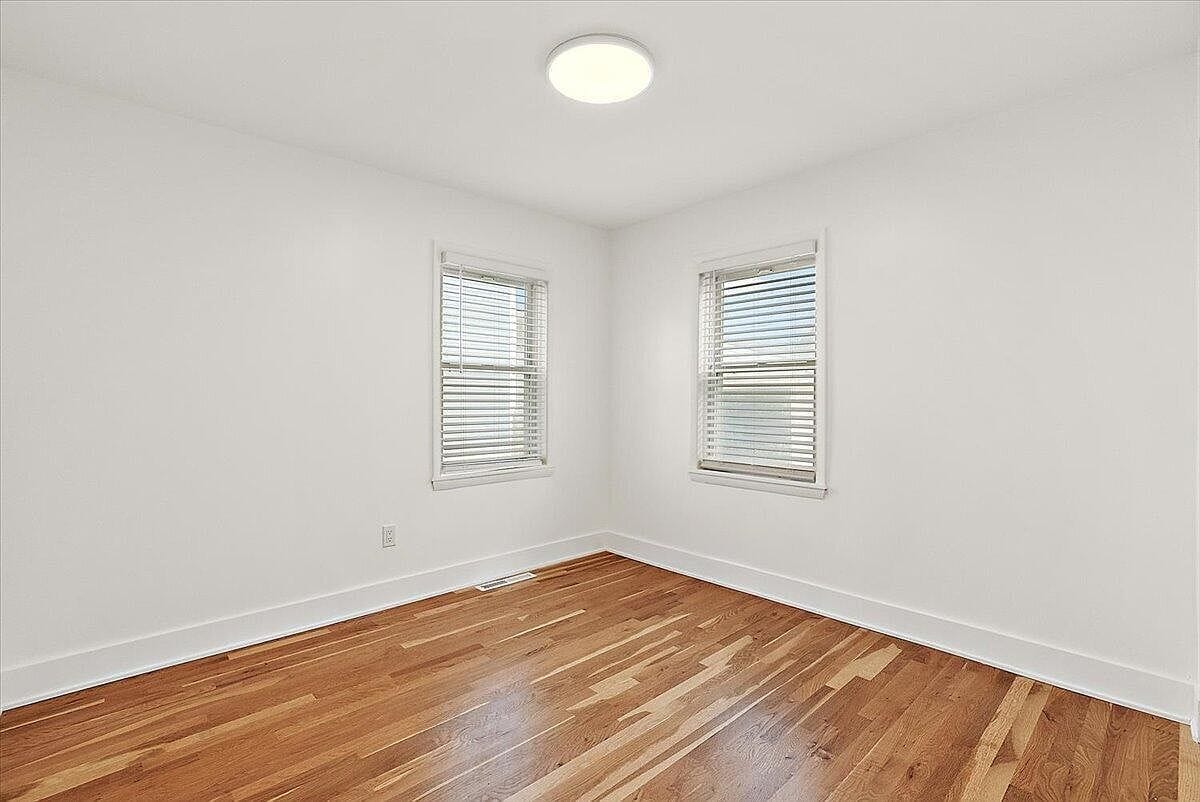 Empty bedroom with white walls and natural light