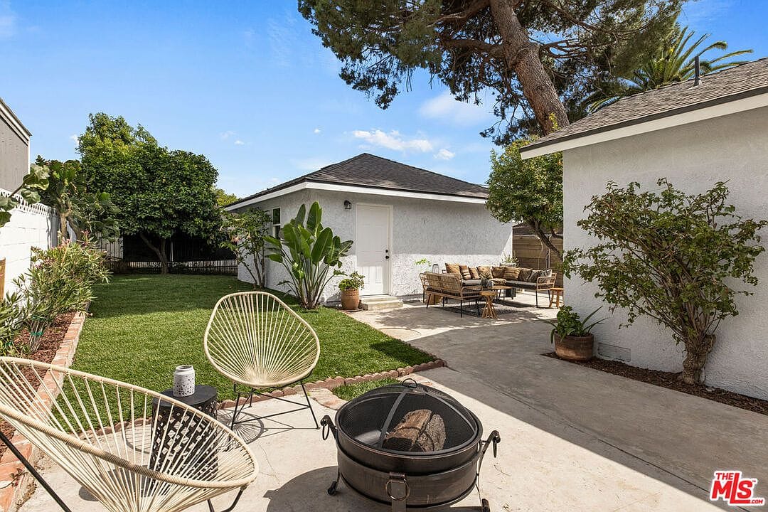 Lawn area with a metal firepit and two woven chairs