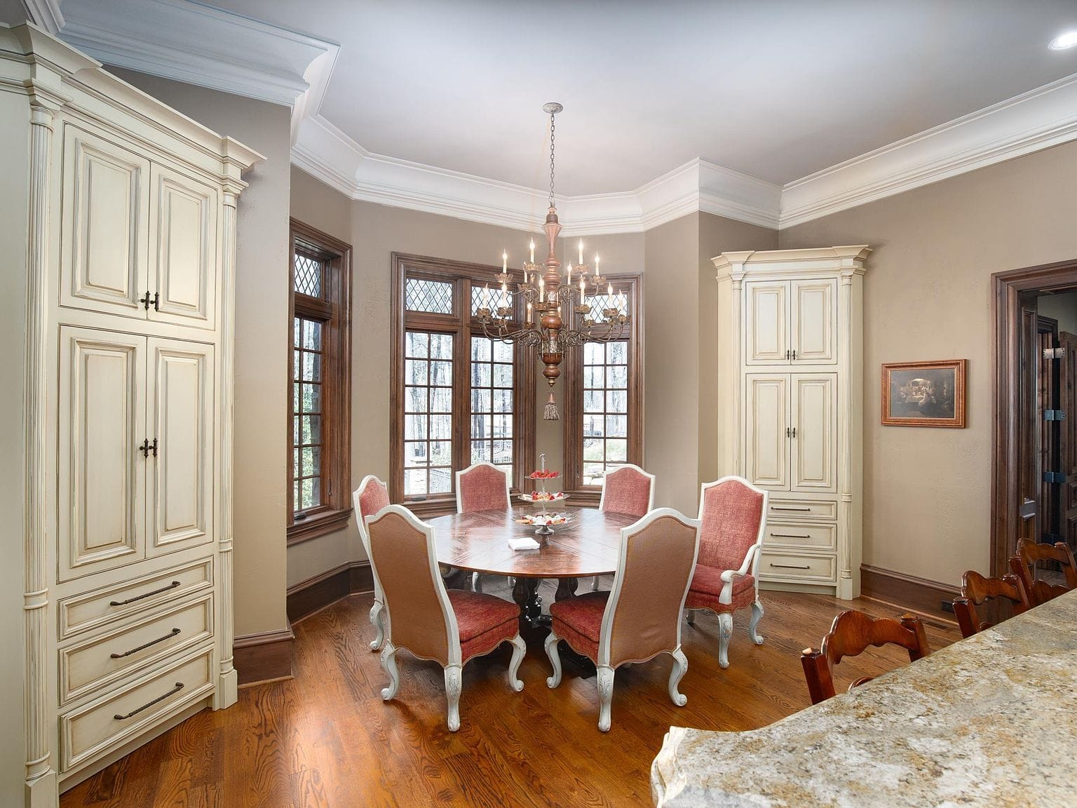 A round dining table in a breakfast nook with built-in cabinets