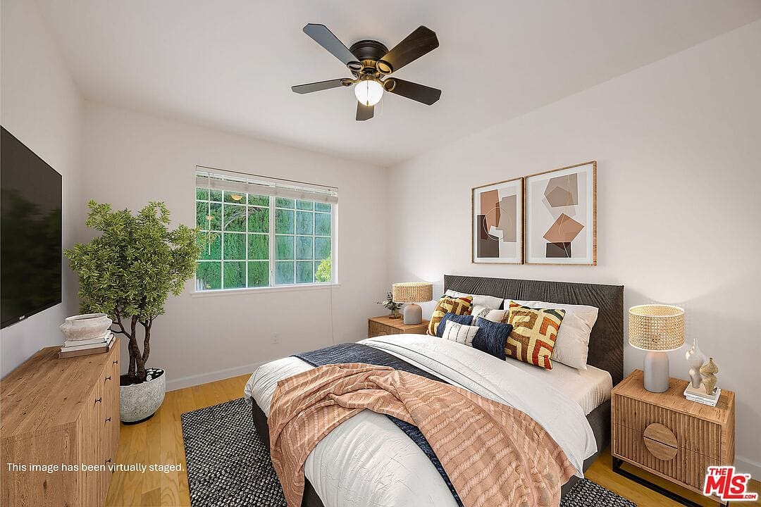 Staged bedroom upstairs with a ceiling fan