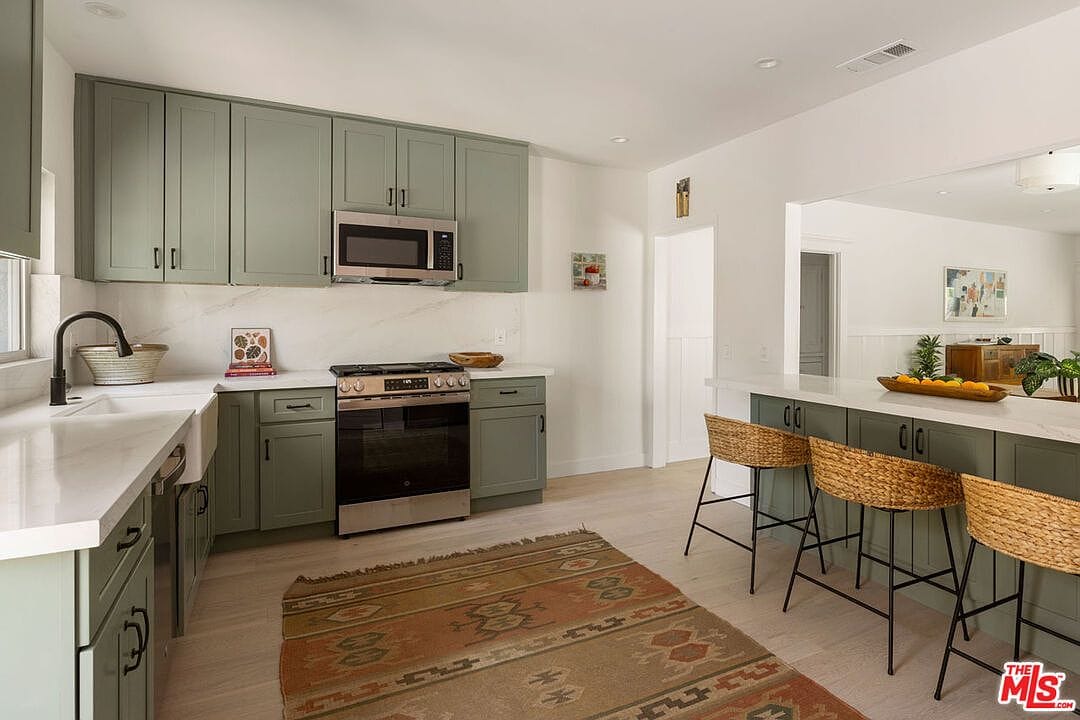 Kitchen island area with three woven barstools