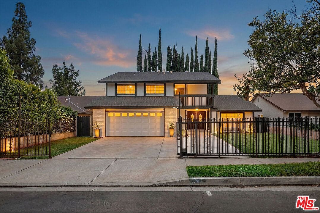 Gated front exterior of the house at sunset