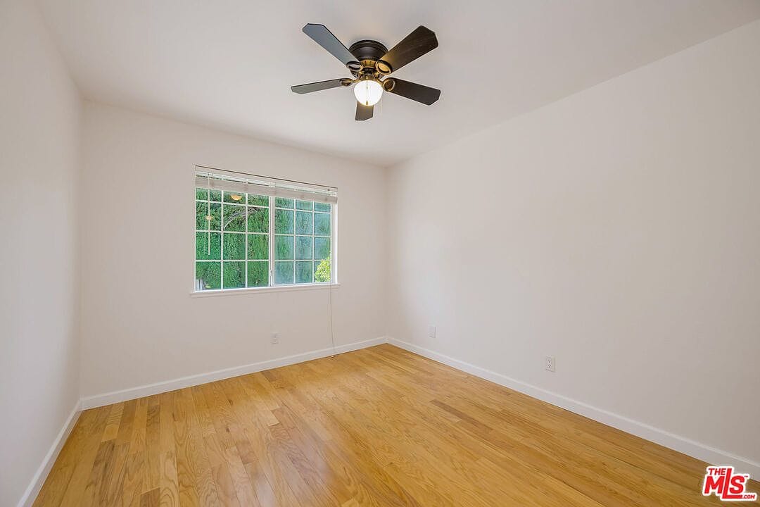 Empty bedroom upstairs with wood floors and window