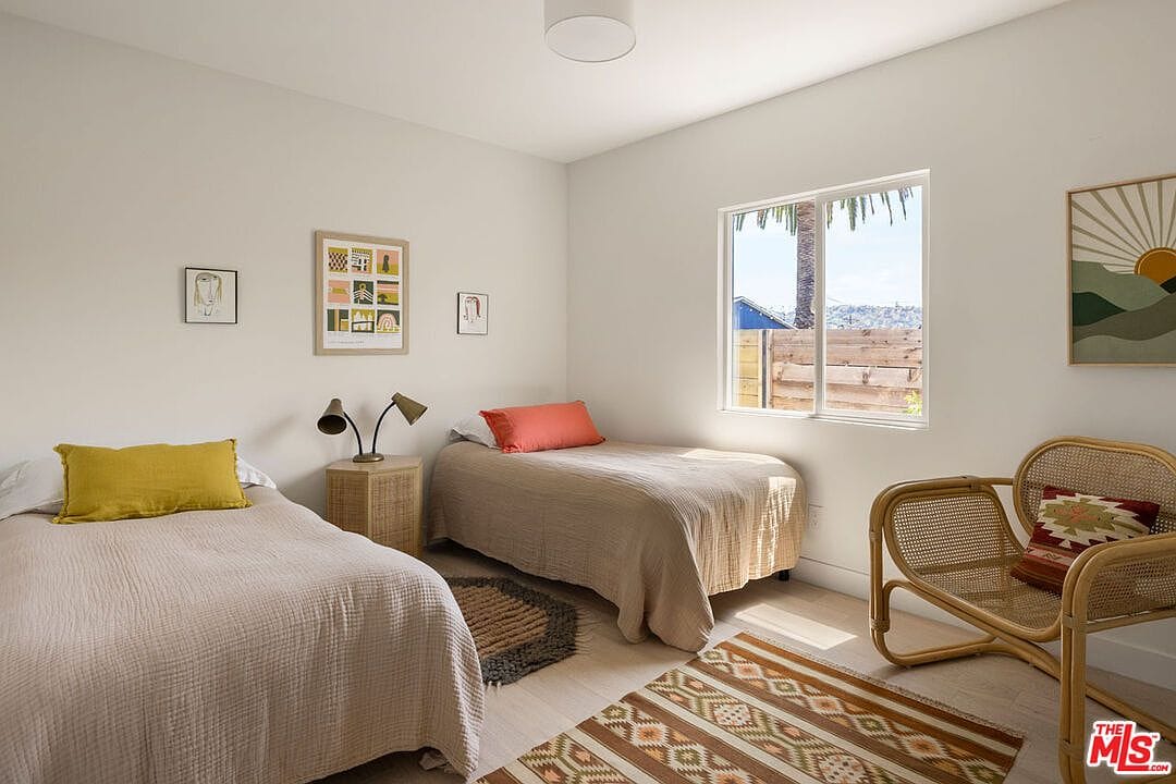 Bedroom with two twin beds and a rattan armchair
