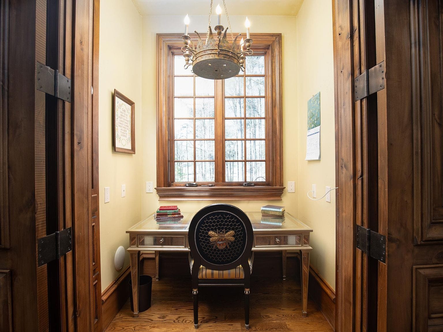 A small desk area hidden behind wooden pocket doors