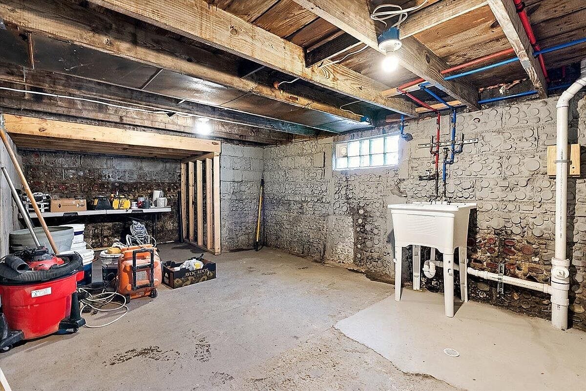 Basement utility area showing a white laundry tub sink